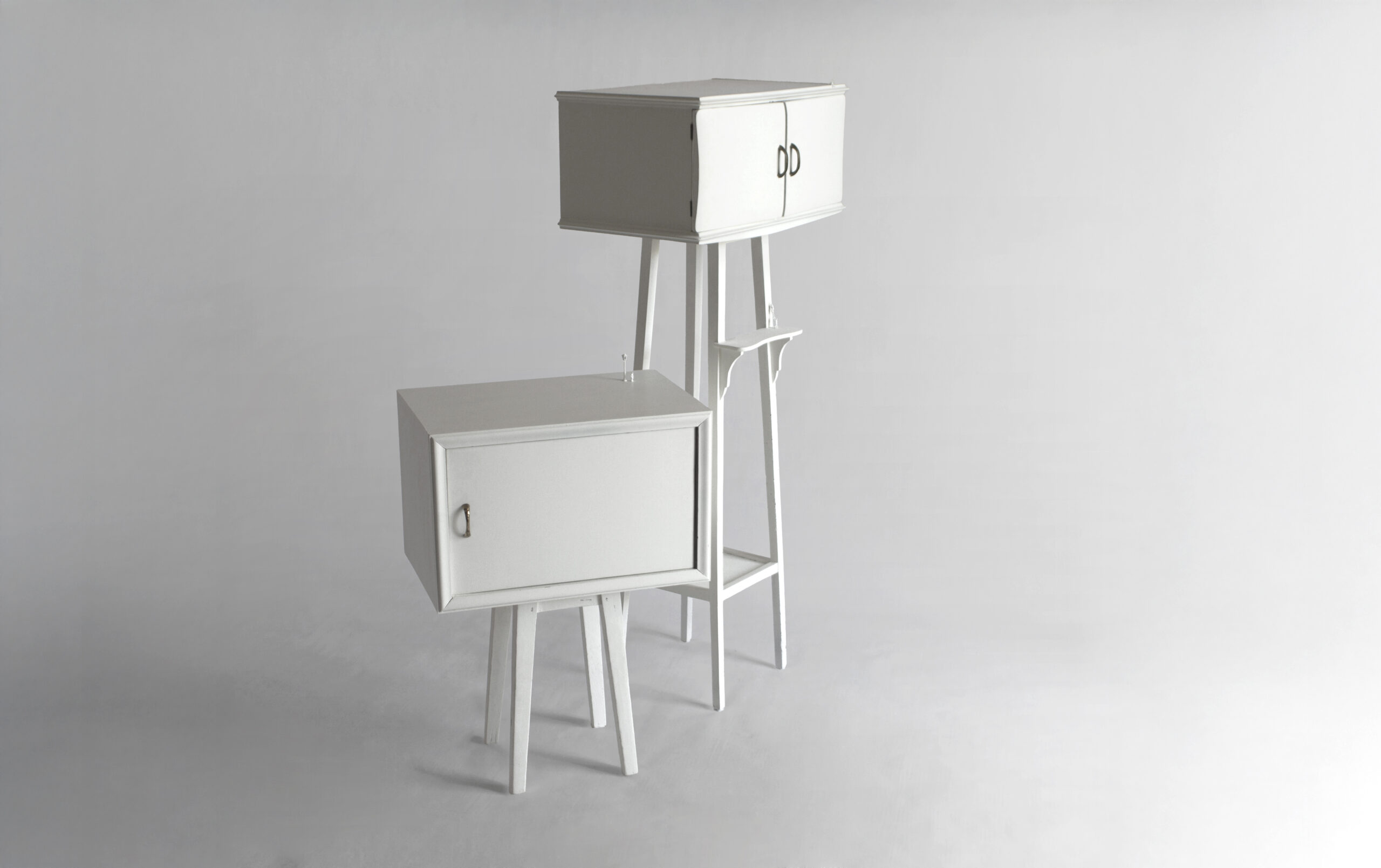 Two white wooden nightstands in their closed configuration, hosting small life scenes inside and outside, interpreted by miniature 1:87 scale figures