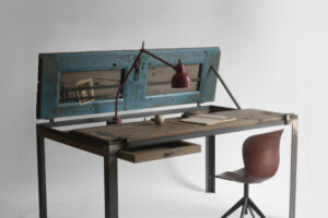 Indoor Blue open in writing-desk configuration with open drawer, chair, lamp and objects on the wooden top
