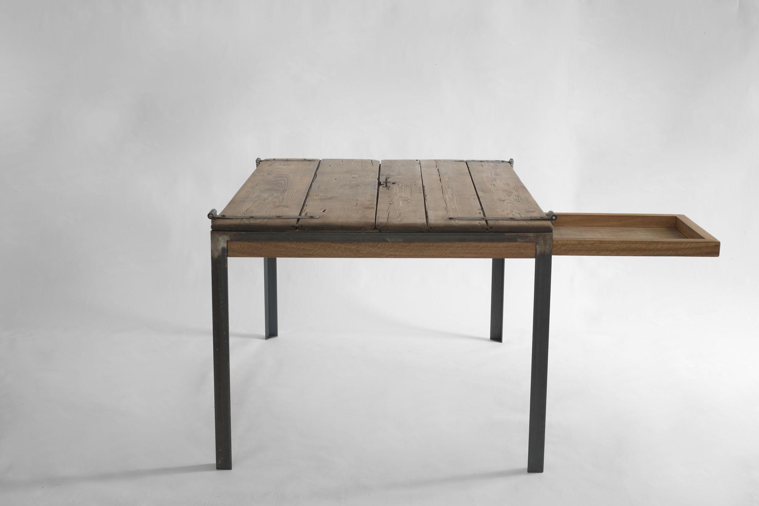 Indoor K table with lift-top opening revealing the internal structure and iron frame