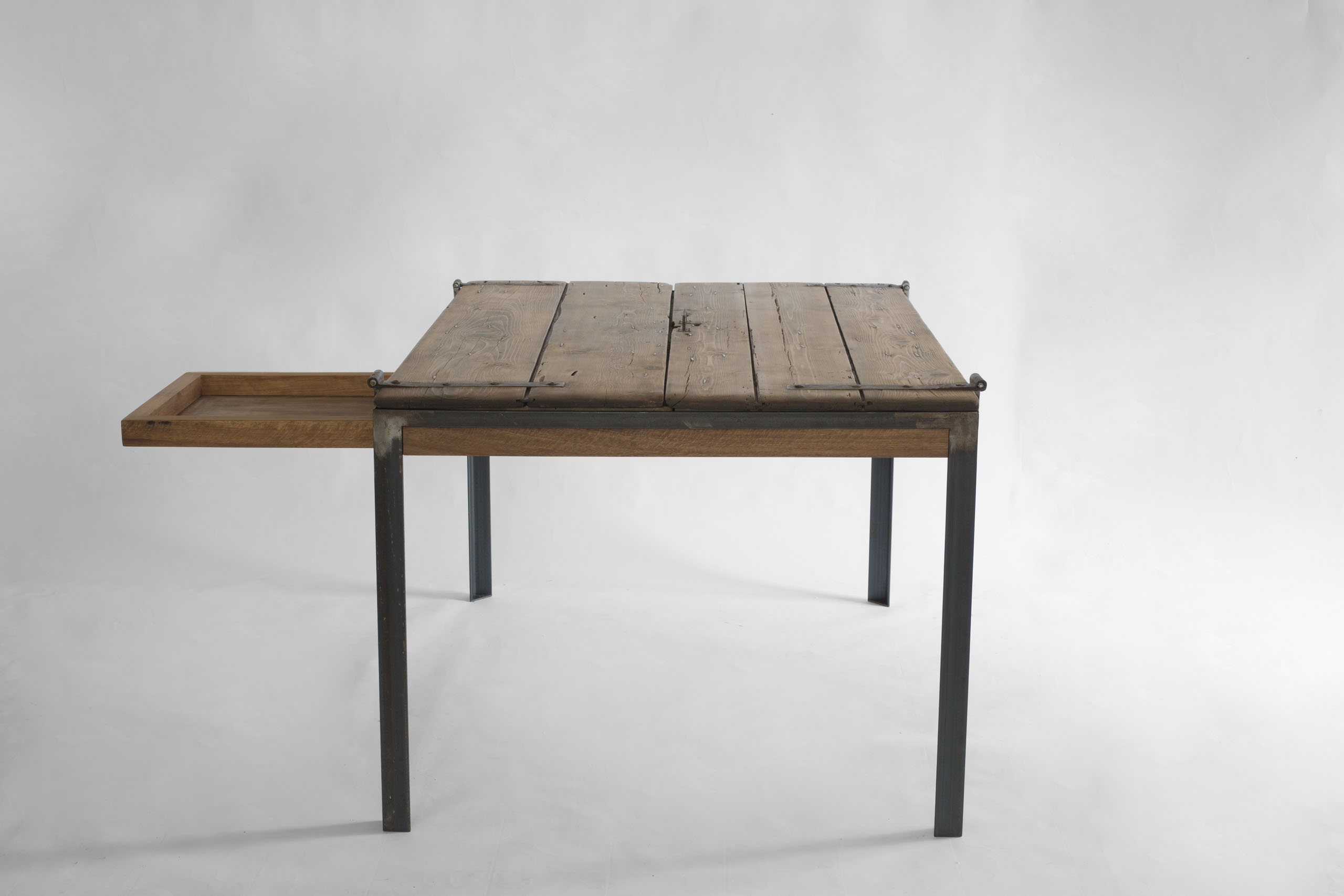 Indoor K table with lift-top opening and lateral drawer extended, transforming into a writing desk
