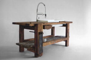 Solid elm carpenter’s table transformed into a kitchen sink with ceramic basin