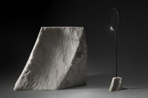 floor standing mirror with small white carrara marble base in dark studio view