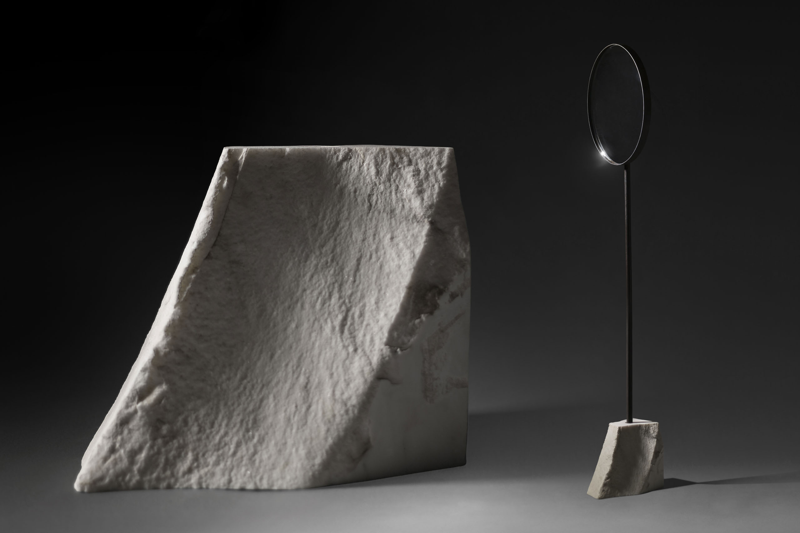 floor standing mirror with small white carrara marble base in dark studio view