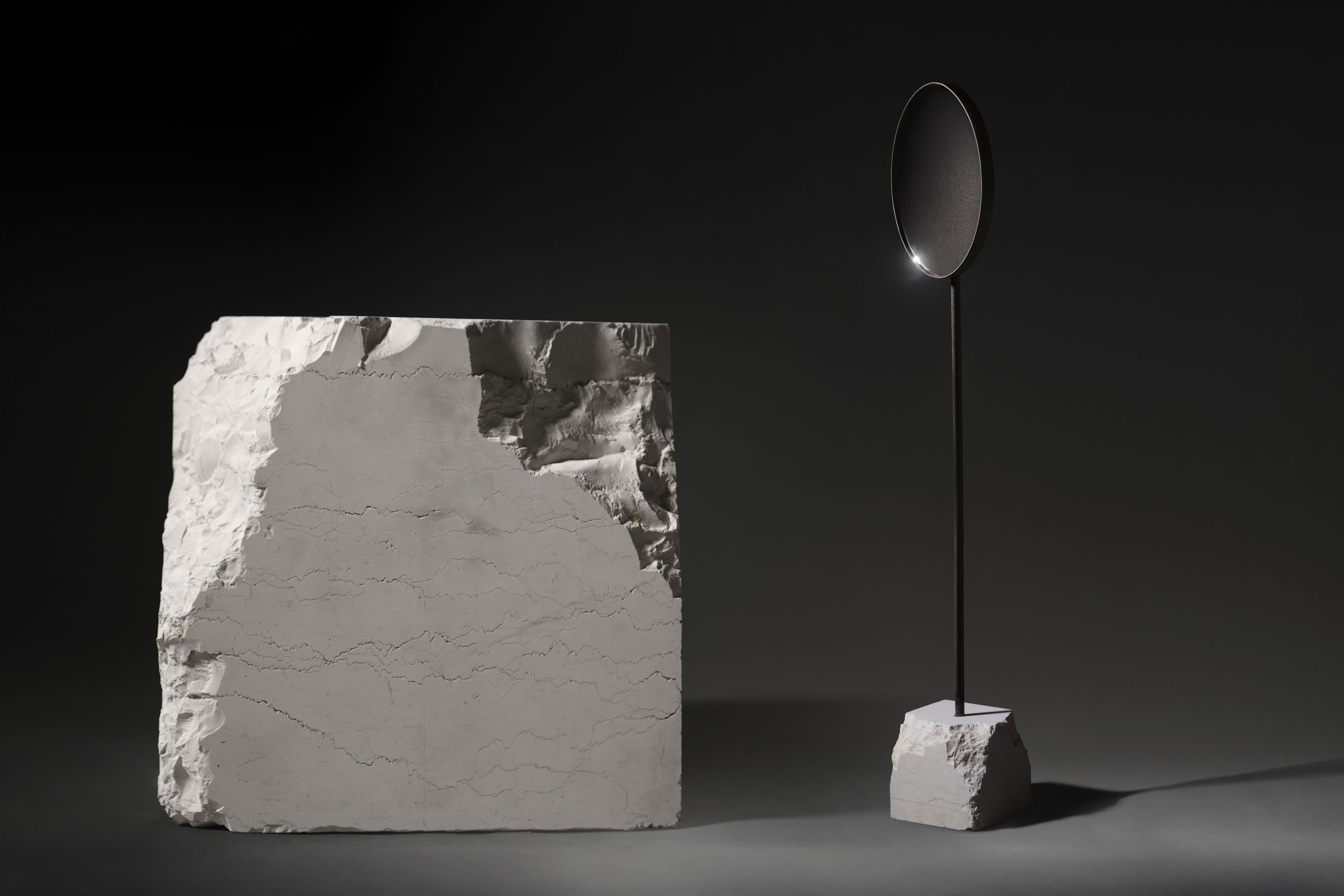 floor standing mirror with white perlino marble base in dark studio view