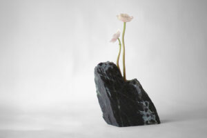 Riquiqui Montaigne #1 sculptural vase in Verde Alpi marble with two pale flowers