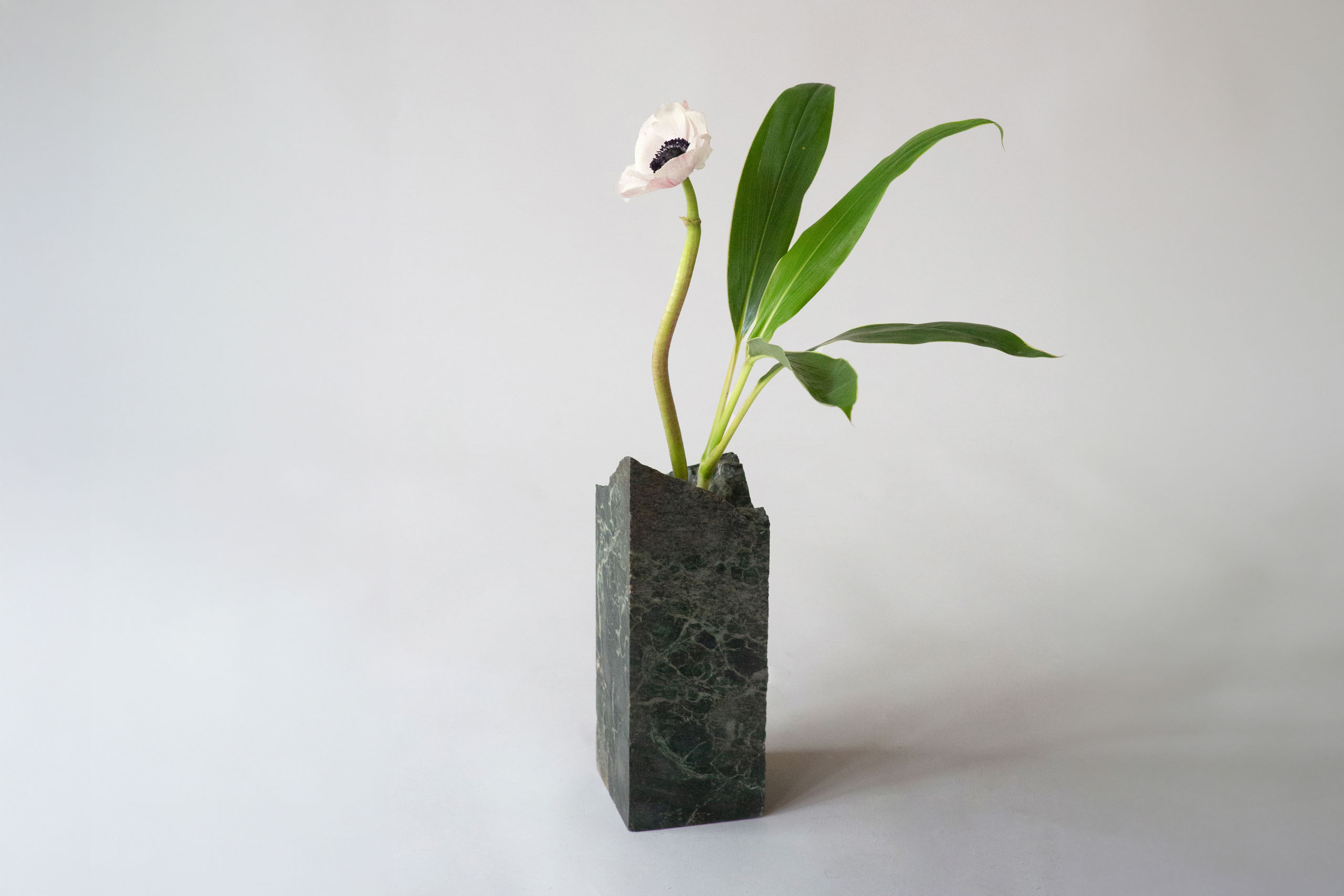 Green Alps marble sculpture vase with an irregular shape and one flower