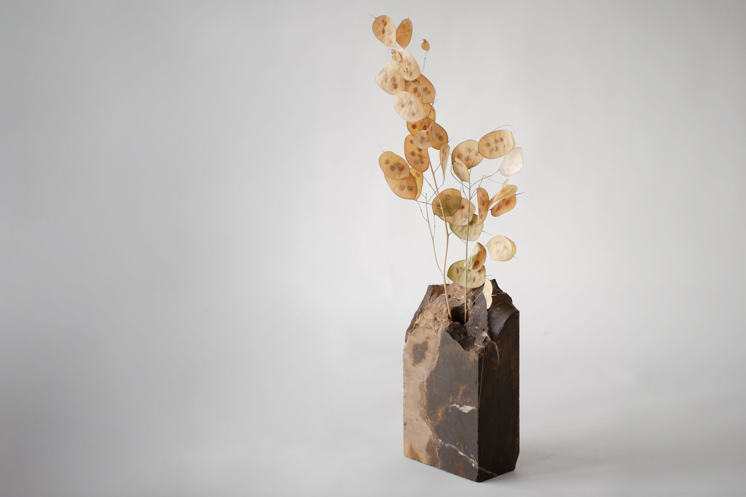 Stone sculpture vase with an irregular shape and flowers
