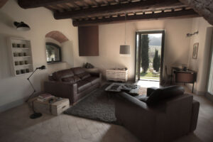 Living room with wooden beams, leather sofas and soft natural light at Salcheto boutique hotel
