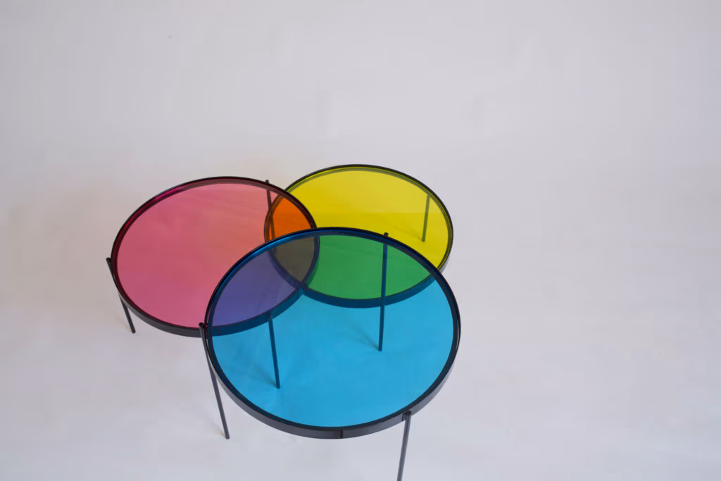 CMYK coffee table by Manoteca, rotation sequence 08: magenta disc rotating further downward, cyan and yellow discs stationary, cyan-magenta violet overlap expanding, central triple intersection dissolving.